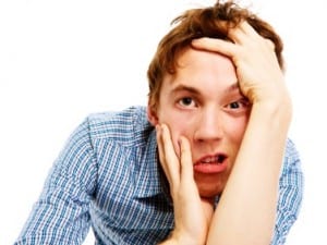 young man pulling funny face on white background